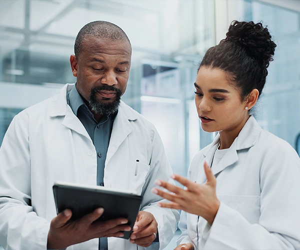 Two scientists looking at tablet